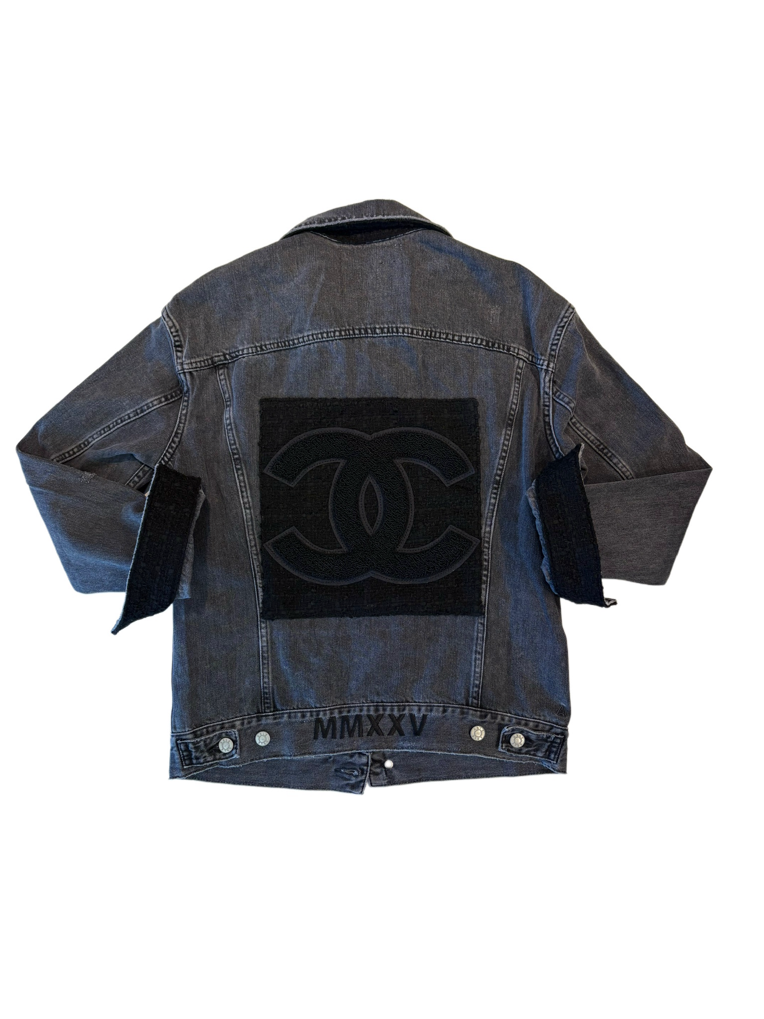 Blue denim jacket with a black patch on a white background
