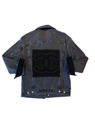 Blue denim jacket with a black patch on a white background